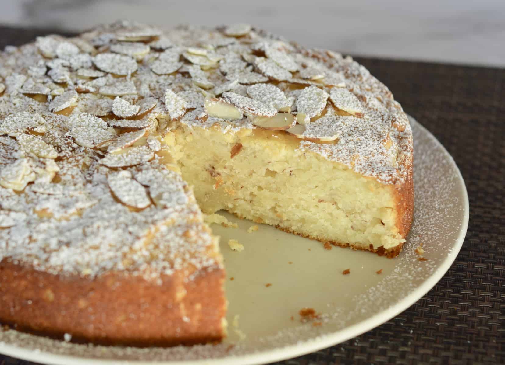 Almond dessert with slice almonds and powdered sugar on top.