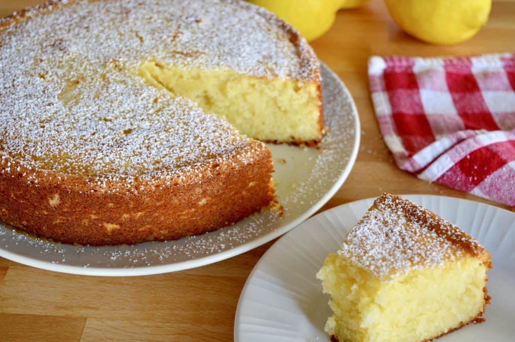 slice of cake on a plate with cut cake in the background. 