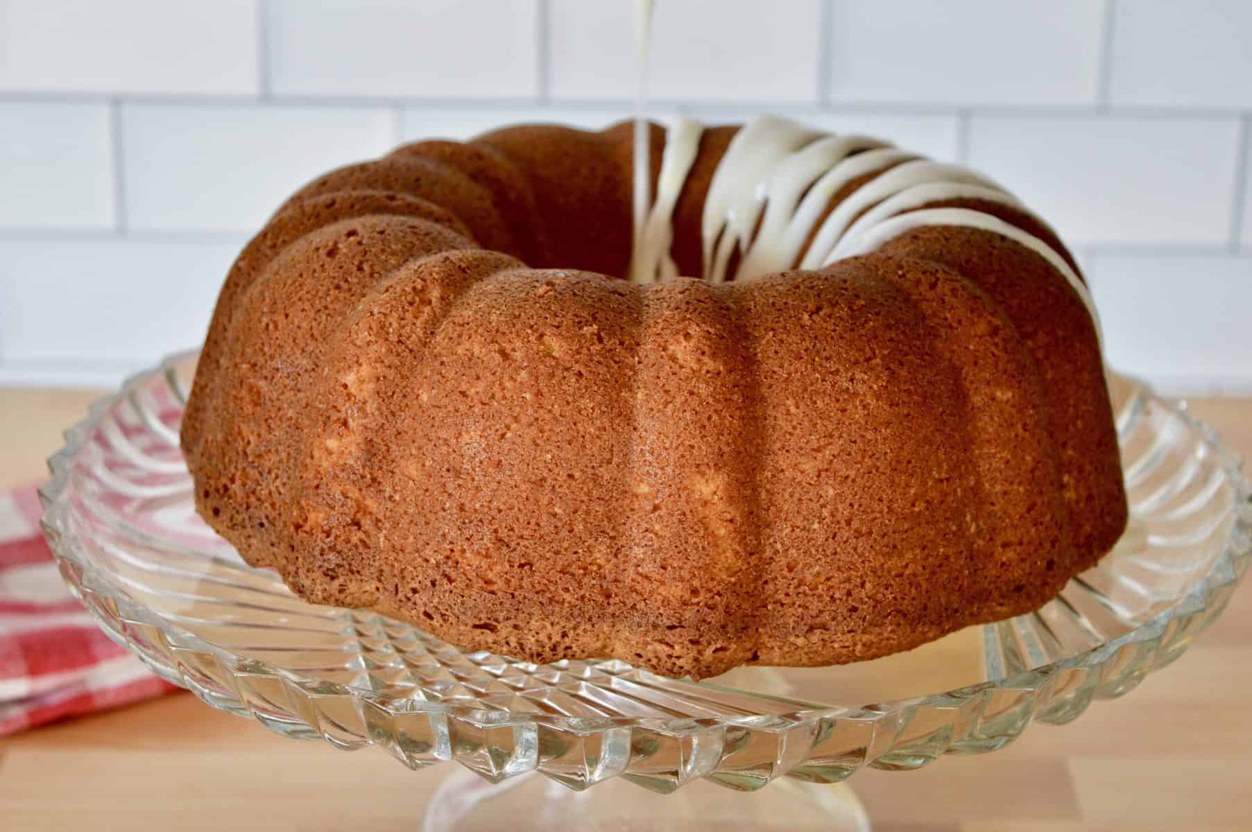 drizzling glaze over dessert on pedestal. 