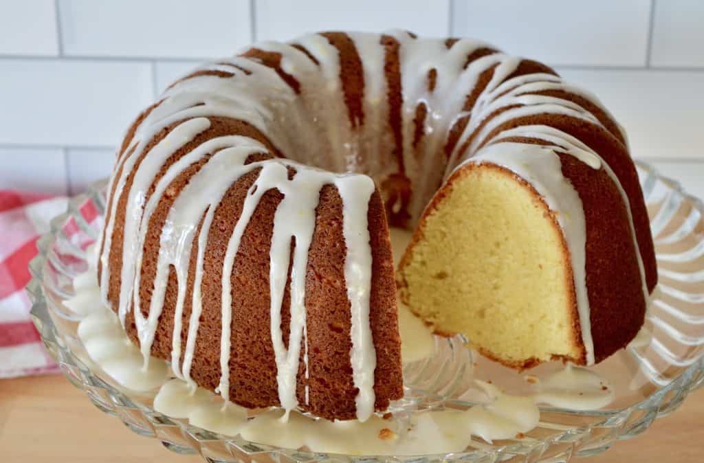 Lemon Olive Oil Bundt Cake with honey lemon glaze on a glass pedestal.
