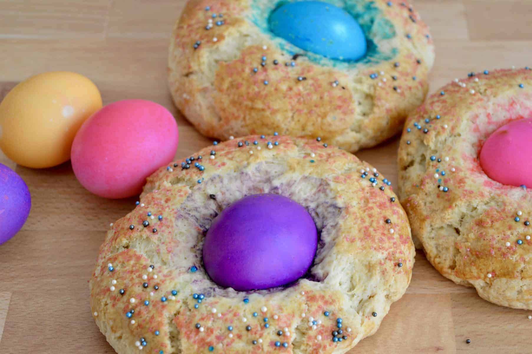 Italian easter bread with sprinkles and a colored egg in the center.