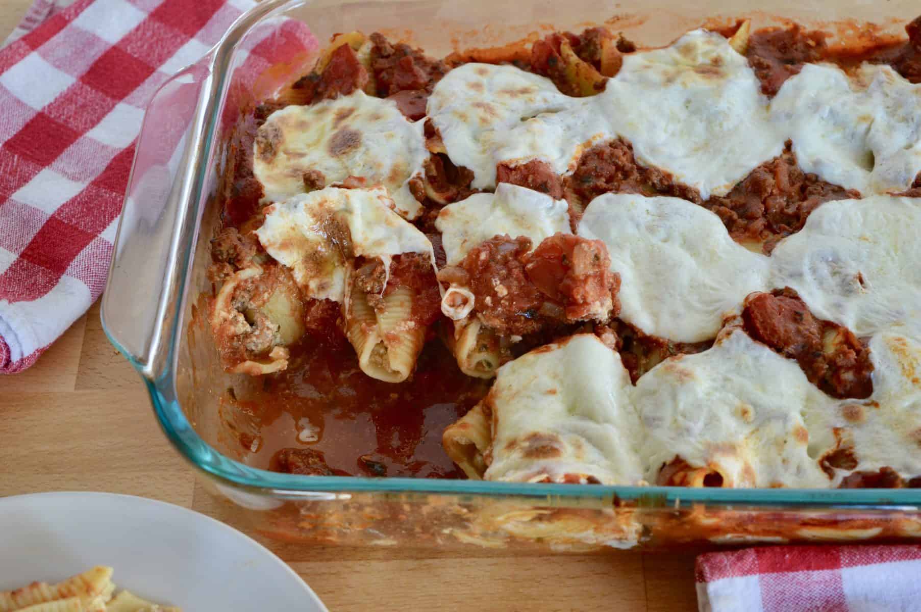 baked pasta in a glass baking dish with mozzarella cheese slices melted on top.