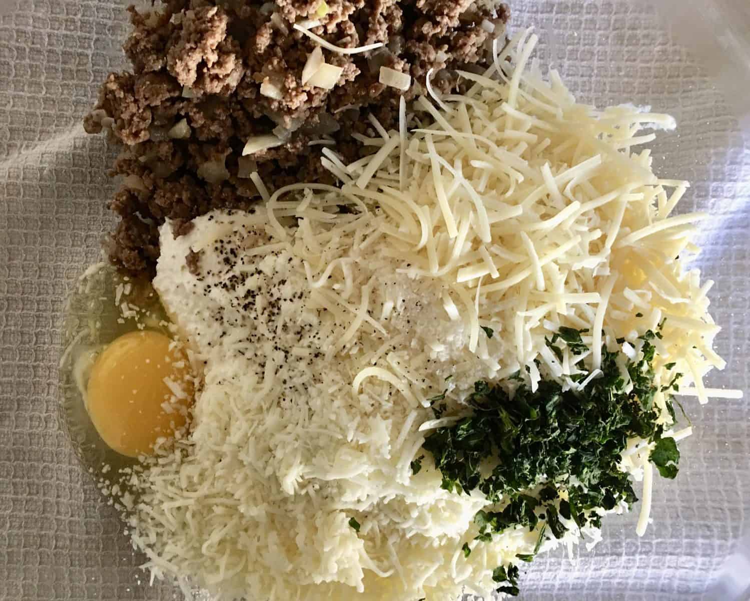 filling ingredients for stuffed shells in a glass mixing bowl.