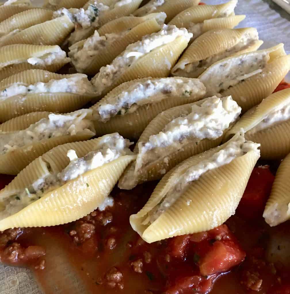 side view of cheese beef stuffed shells in a baking dish.