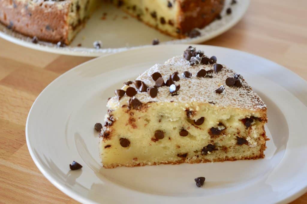 slice of chocolate chip ricotta cake on a white plate.