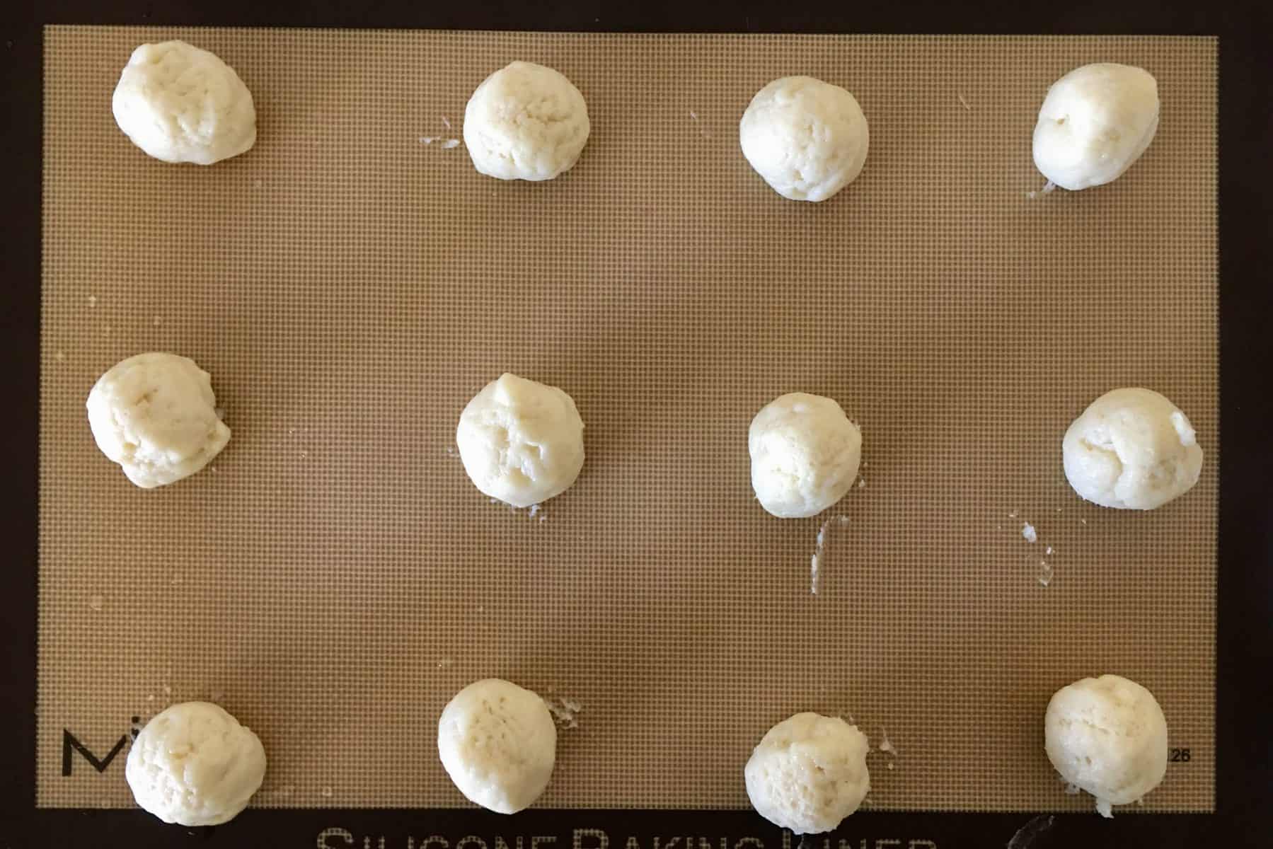 dough balls on a baking sheet . 