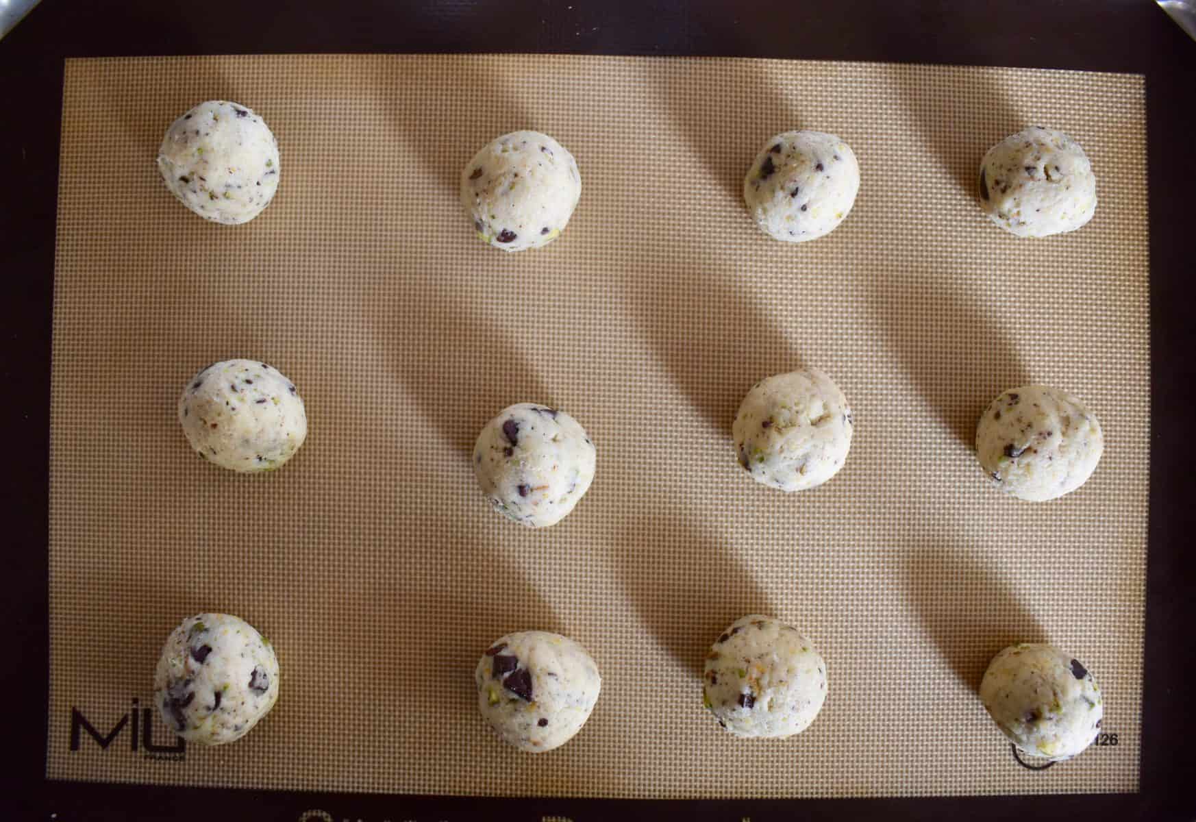 batter rolled into balls on a non stick baking mat. 