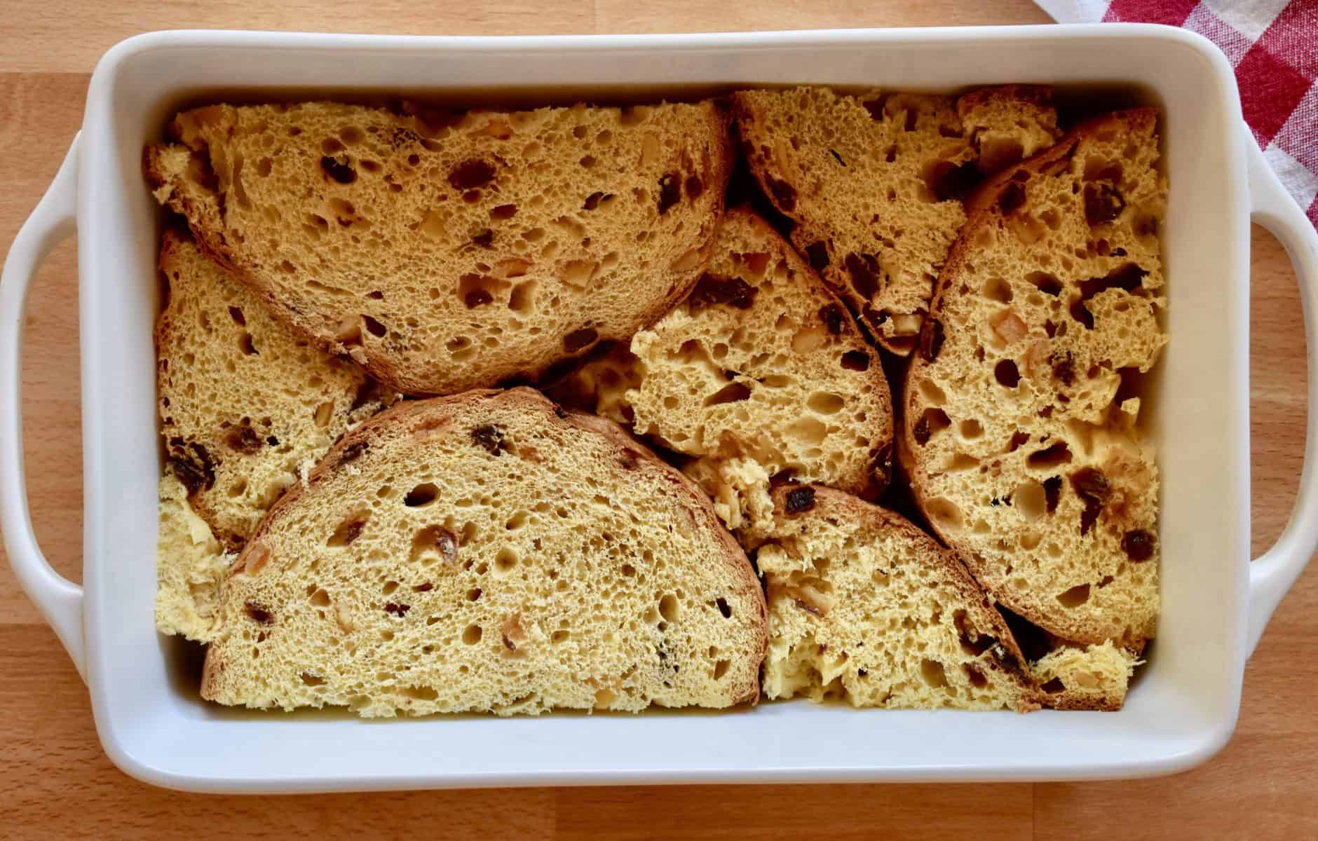 slices of panettone in a white baking dish. 