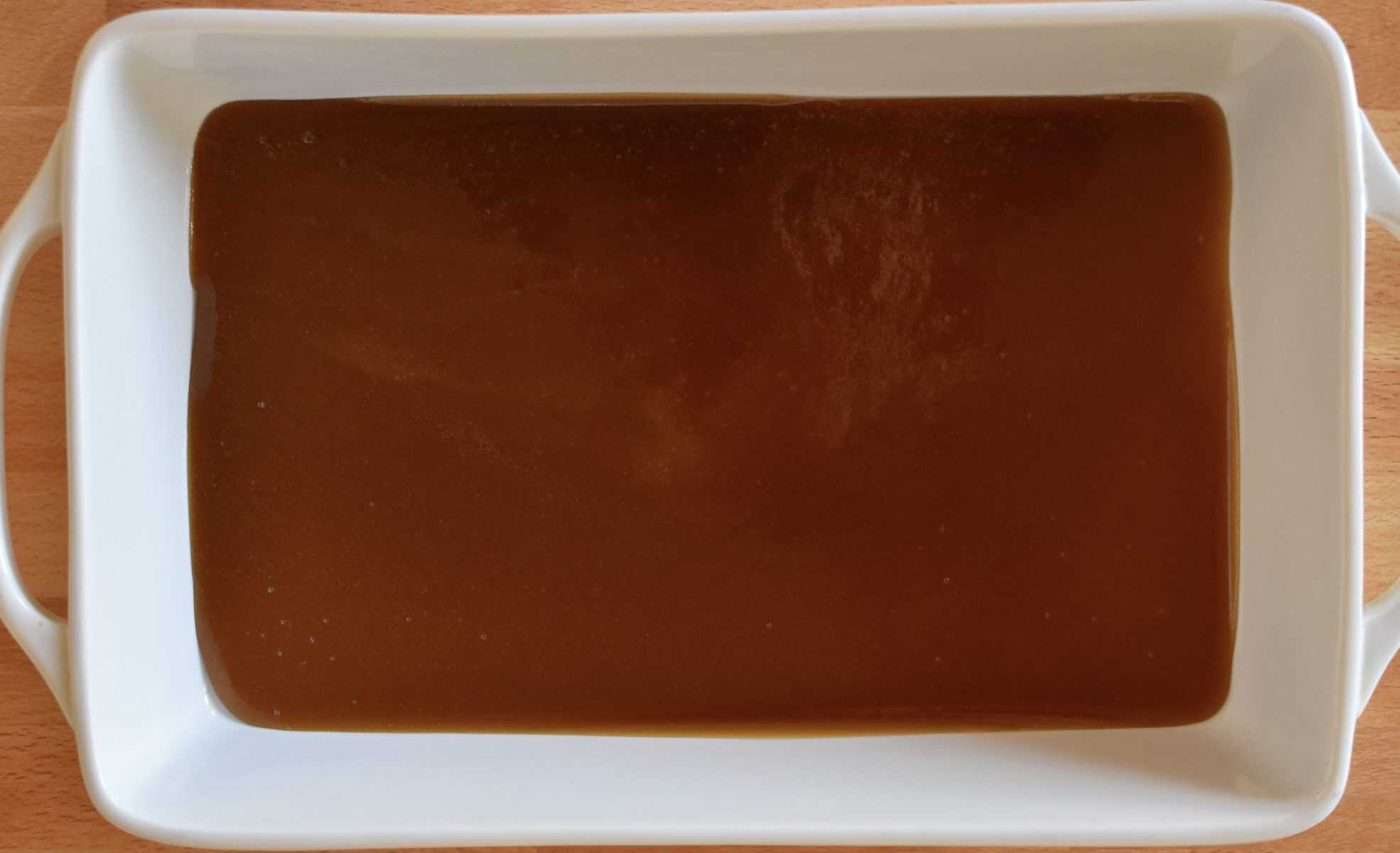 brown sugar butter mixture on the bottom of a white casserole dish. 