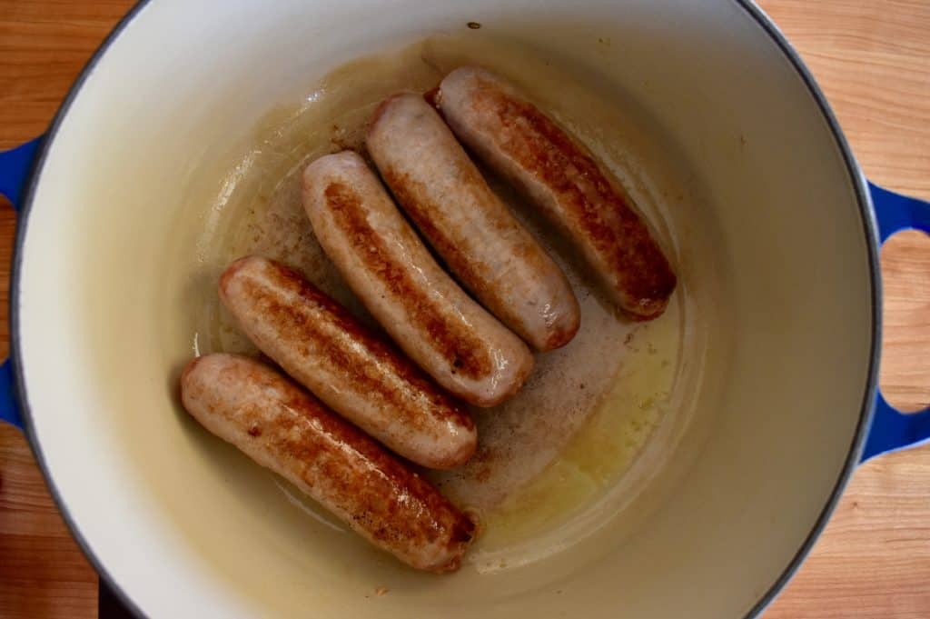 Sausages browned in a dutch oven skillet.