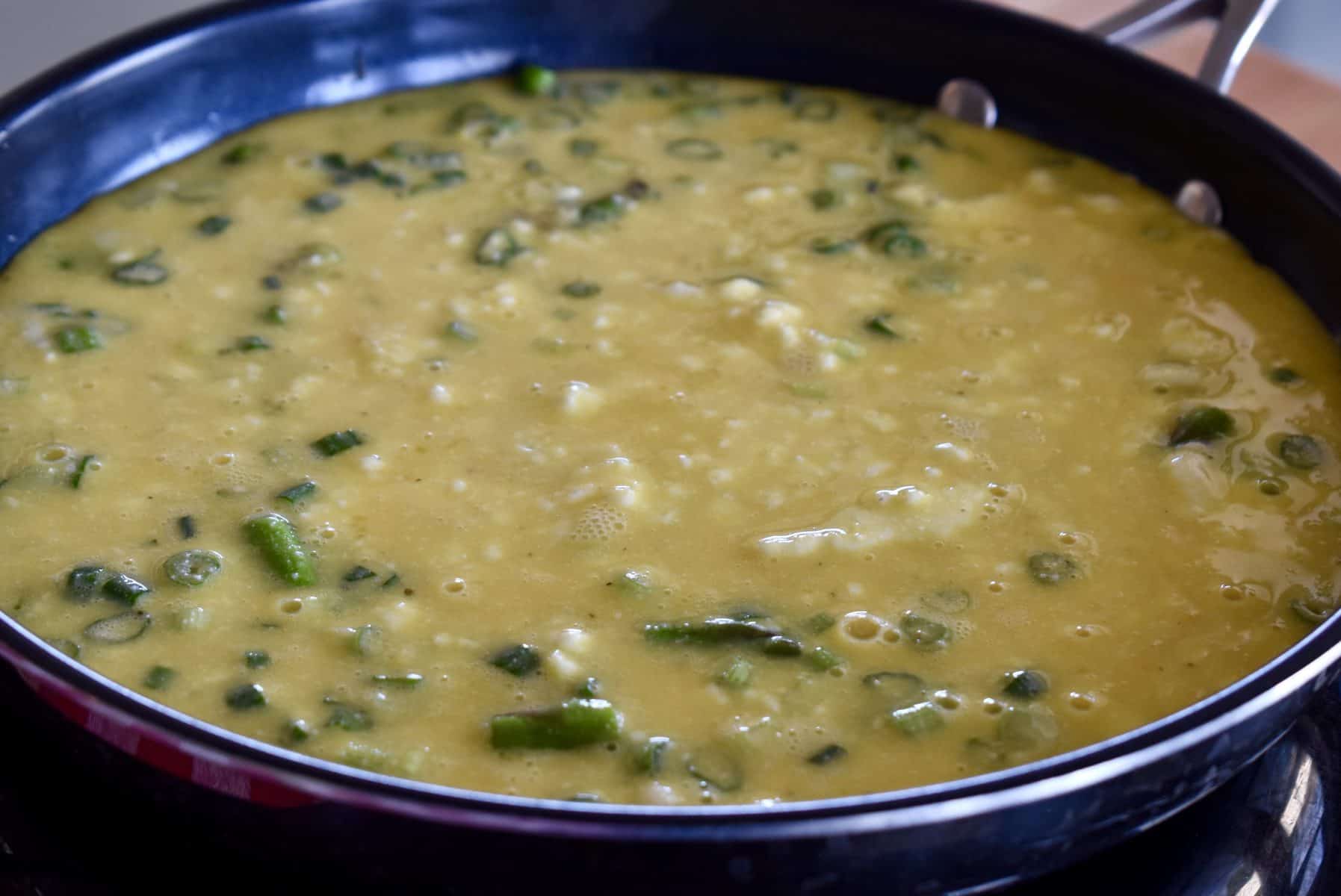 eggs poured over the veggies in the pan. 