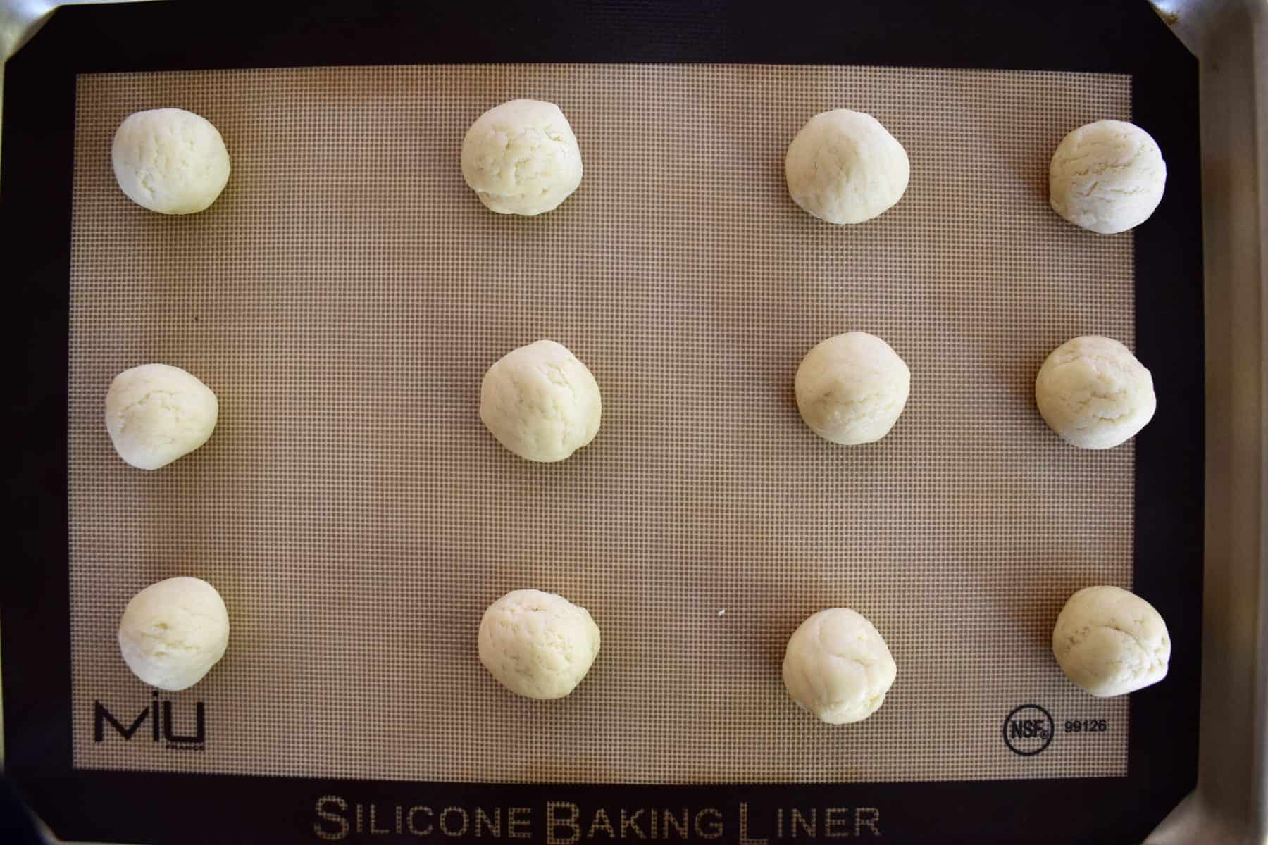 balls of dough on a lined sheet pan. 