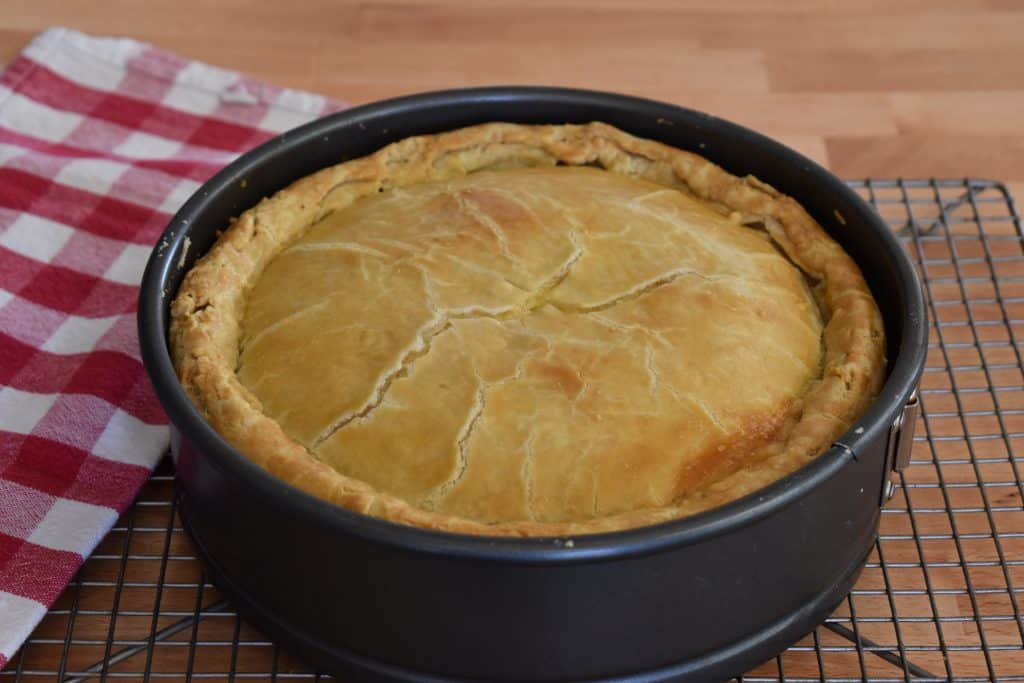 Italian Easter Pie in a springform pan on a cooling rack.
