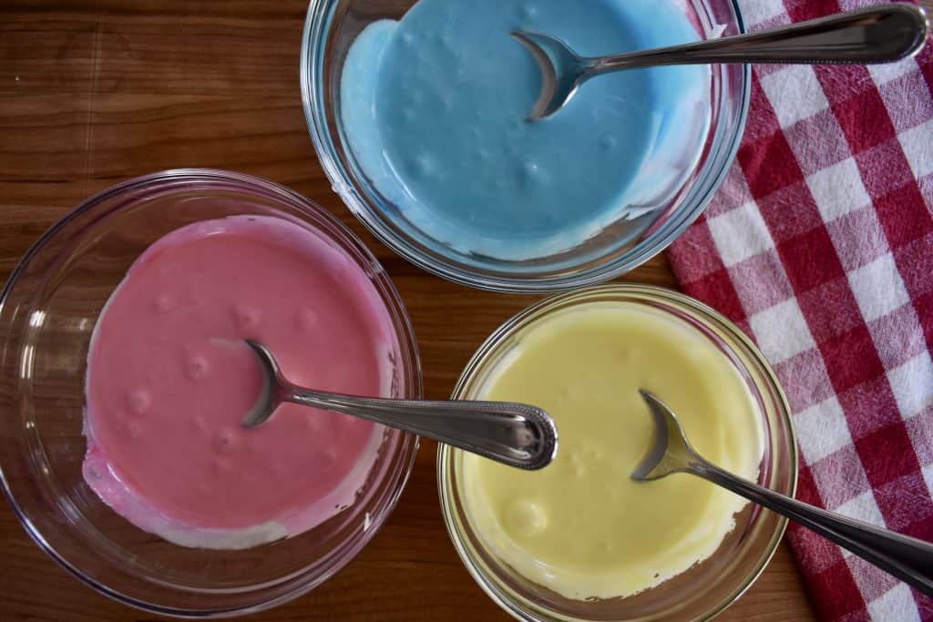 overhead photo of three bowls of frosting for the cookies.