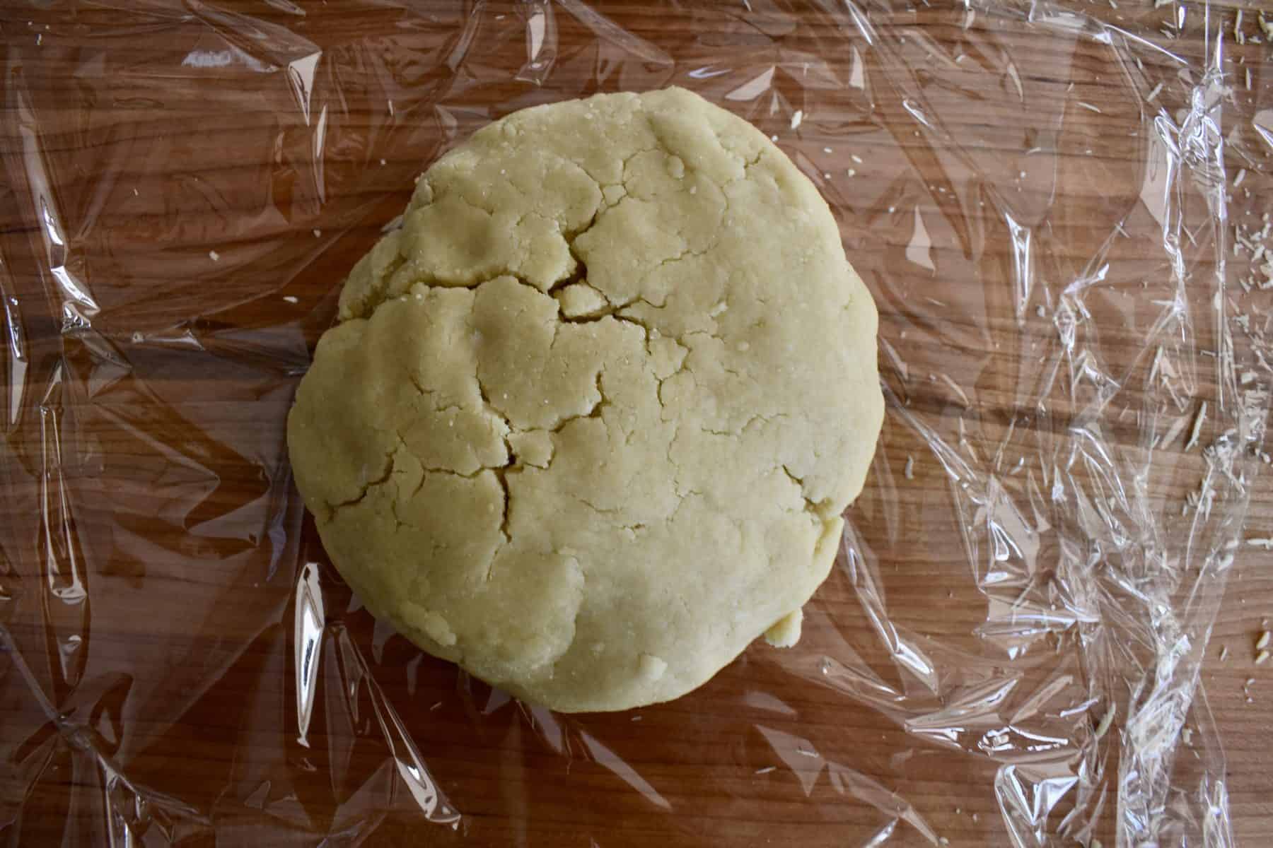 pie crust ball on top of a piece of plastic wrap