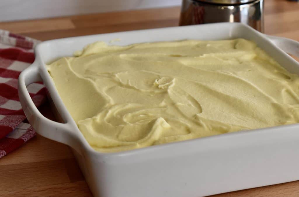 Custard spread over top of the ladyfingers.