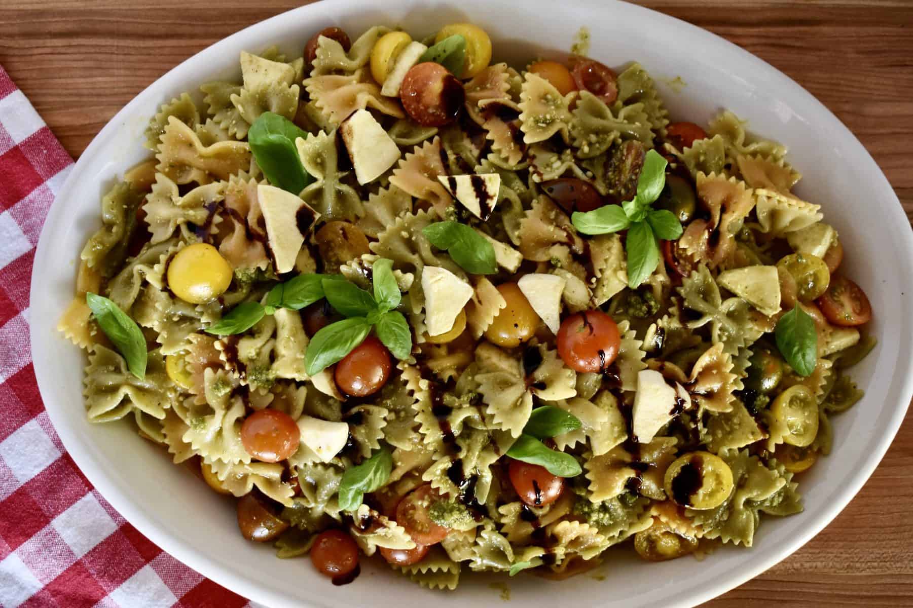 overhead photo of 5 ingredient pest pasta salad in a white oval platter. 