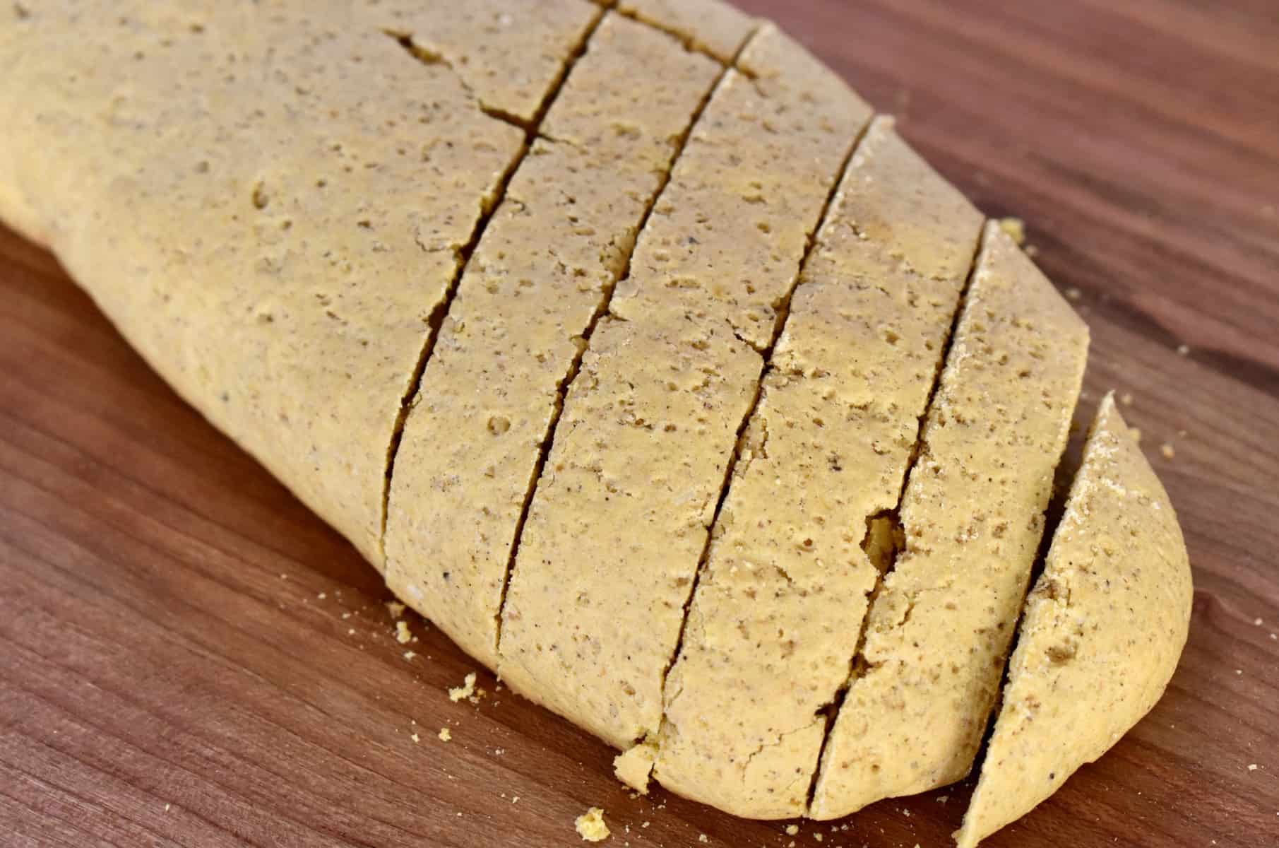 close up of sliced dough on a wooden cutting board. 