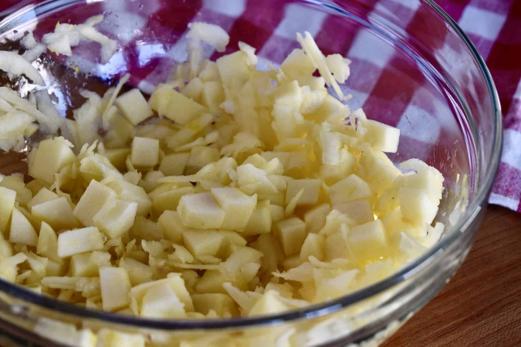 diced apples in a bowl tossed with lemon juice and lemon zest. 