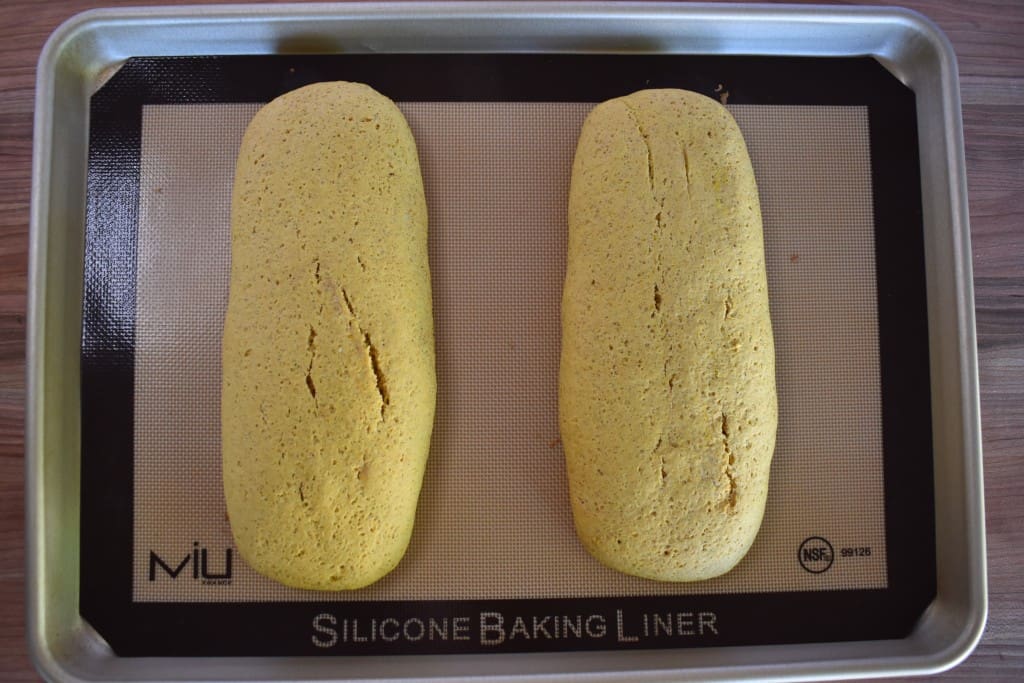 baked pumpkin biscotti logs on a baking sheet. 