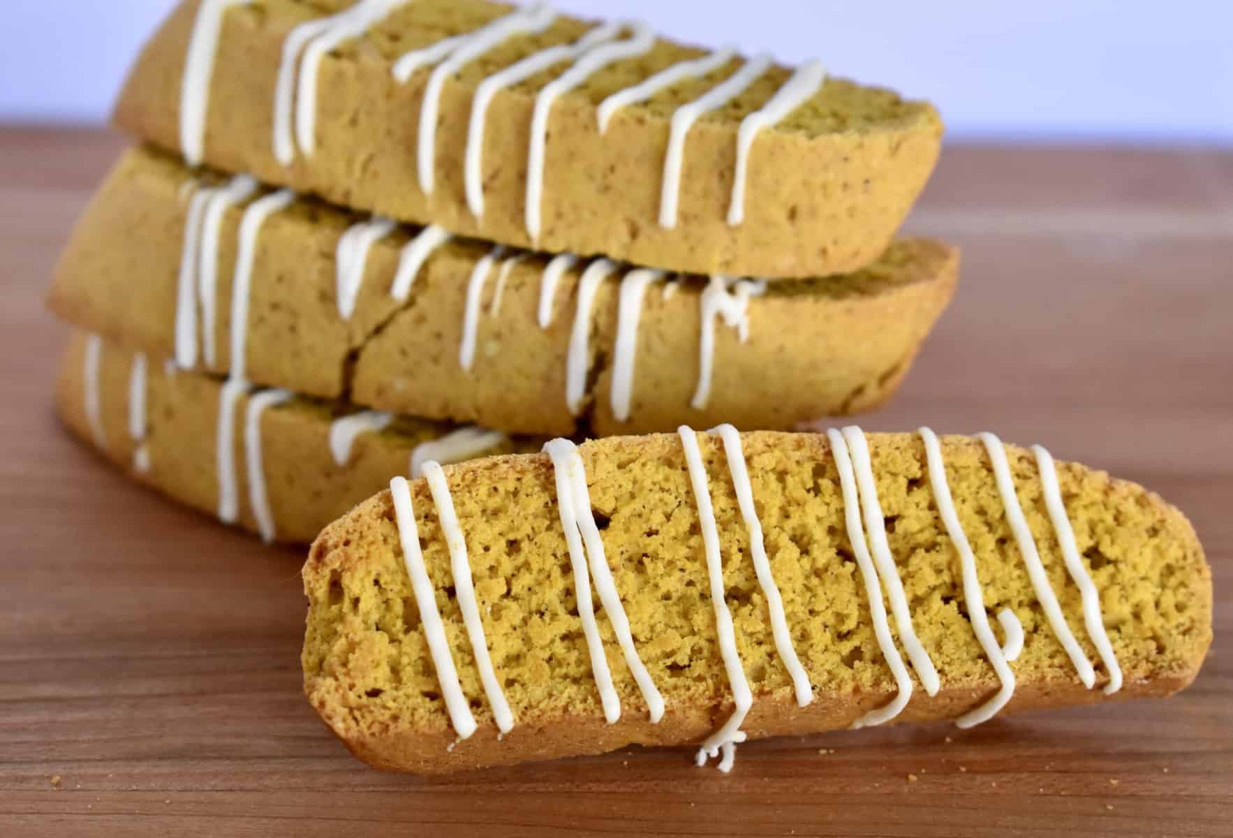 pumpkin biscotti stacked high on a wood cutting board. 