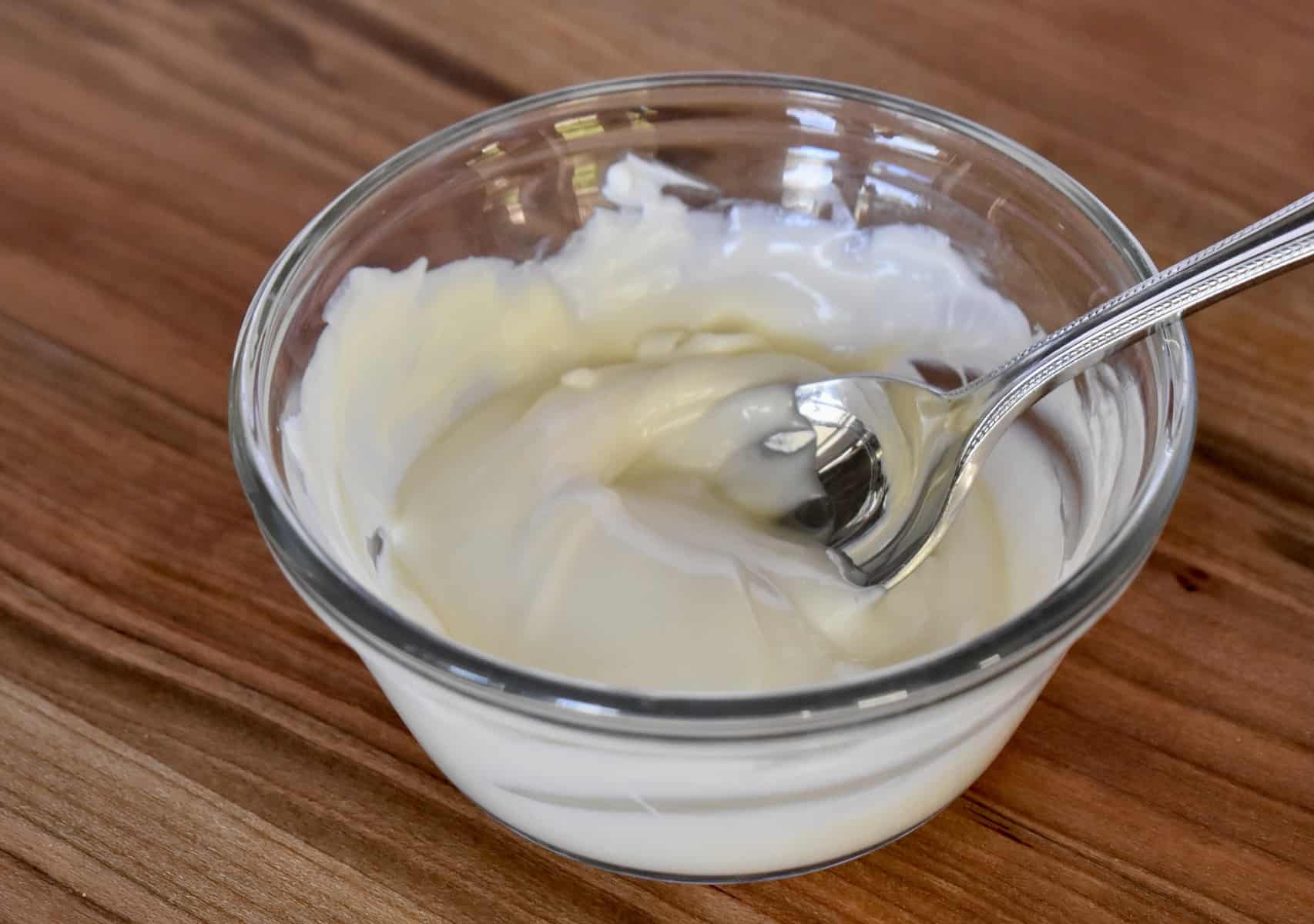 small glass bowl with melted white chocolate and a spoon. 