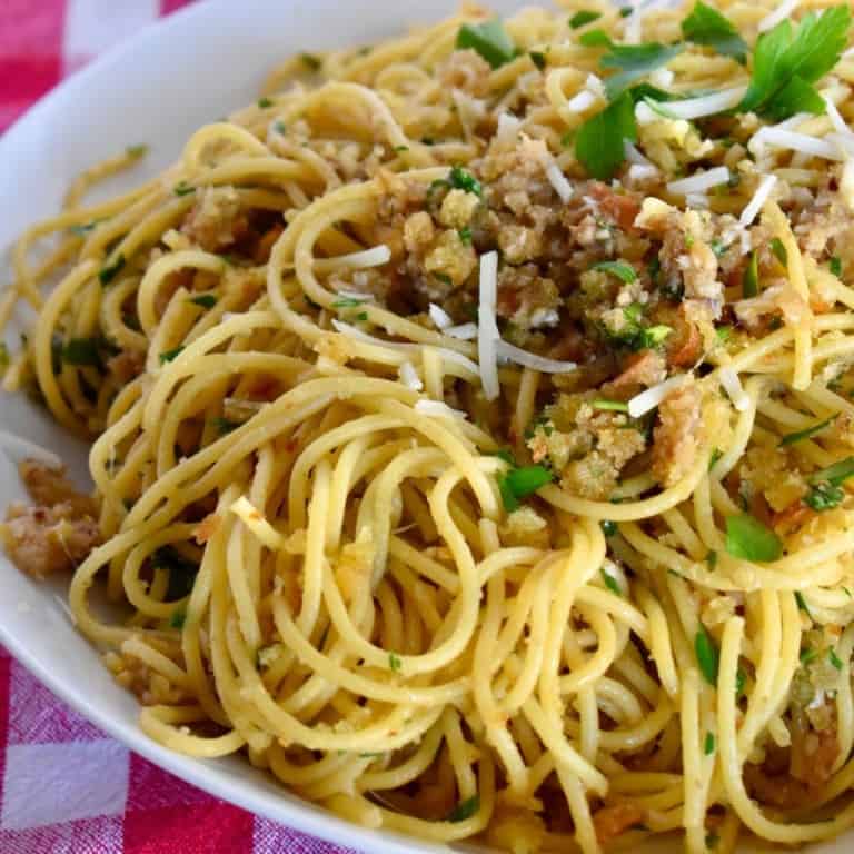 Anchovy Breadcrumb pasta in a white bowl on a checkered cloth.