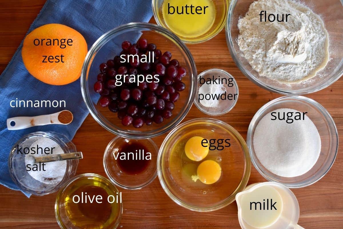 overhead photo of ingredients needed to make the recipe including flour, orange zest, olive oil, eggs, and milk. 