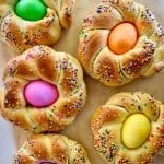 overhead photo of Italian Easter bread with dyed eggs in the middle.