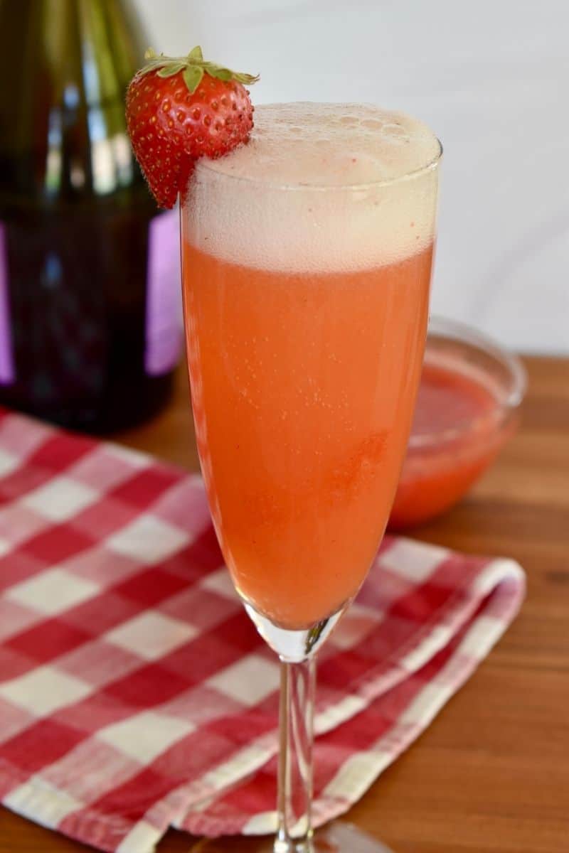 Rossini Cocktail in a champagne glass made with prosecco and strawberry puree. 