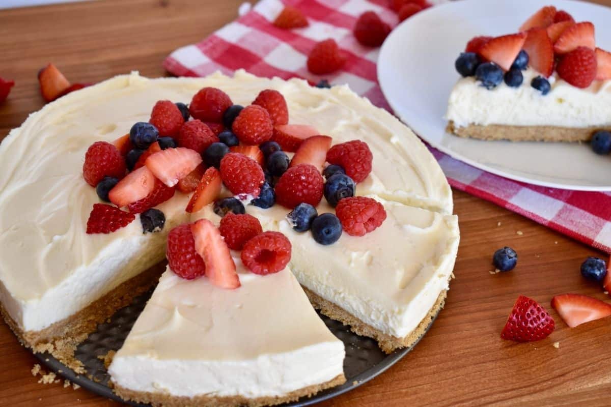 No bake ricotta cheesecake on a plate with fresh berries on top. 