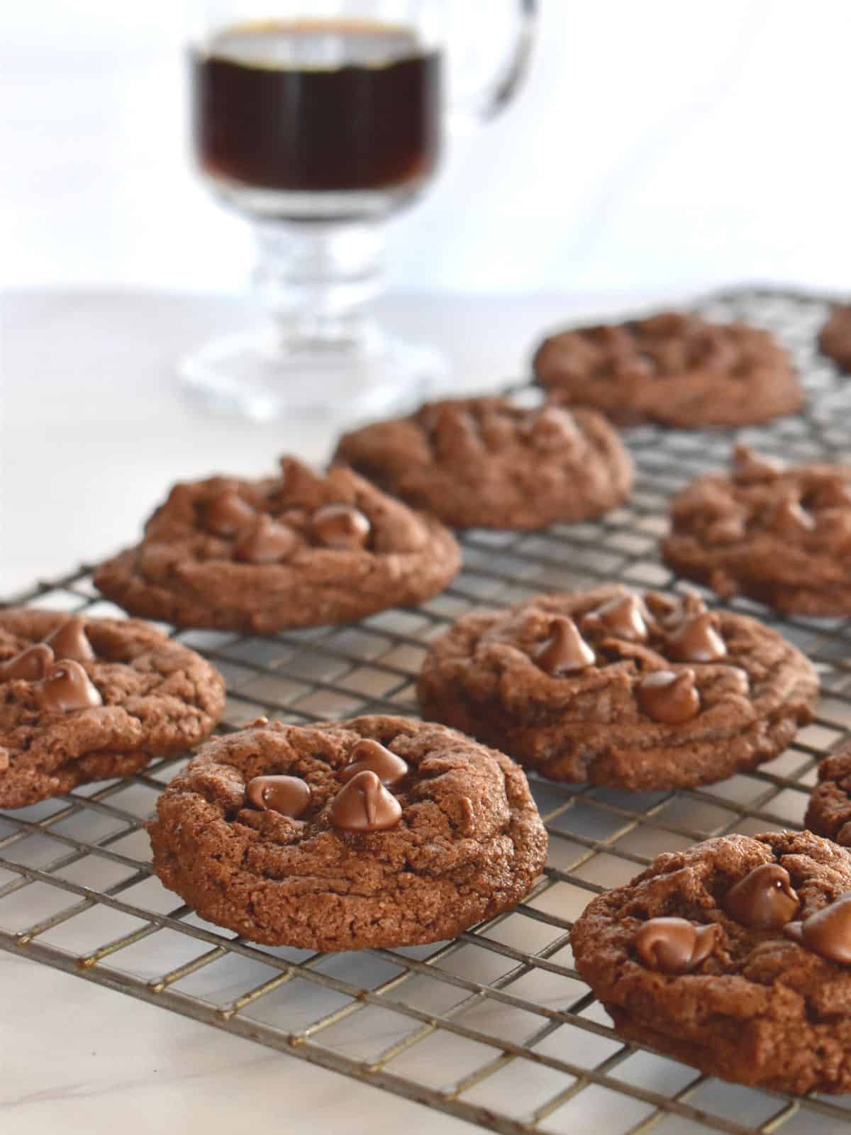 Chocolate Espresso Cookies on a wire cooling rack with a cup of espresso in the background. 