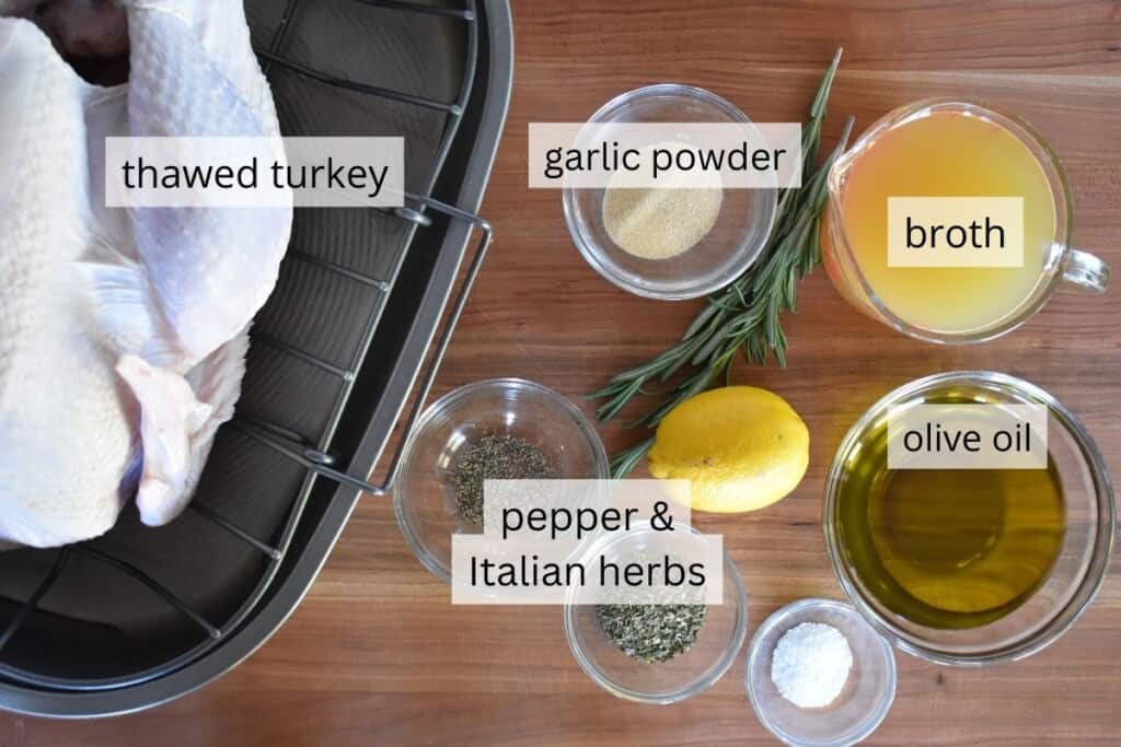 overhead photo of ingredients needed for recipe including broth, rosemary, lemon, salt, pepper, and seasoning. 