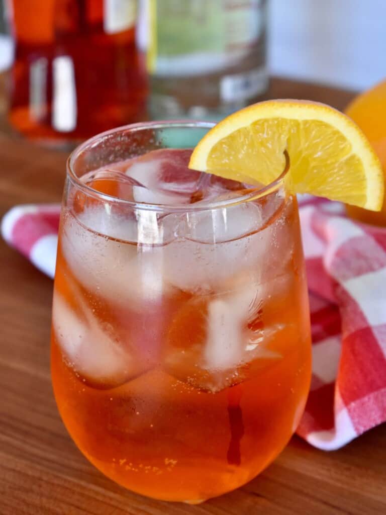 Aperol Soda in a glass with an orange garnish. 
