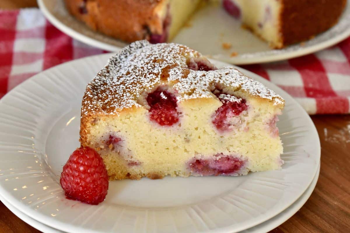 Raspberry Ricotta Cake slice on a white plate. 