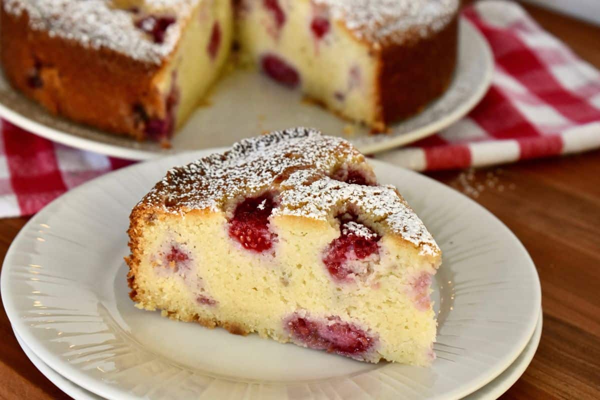 slice of raspberry ricotta cake on a white plate. 