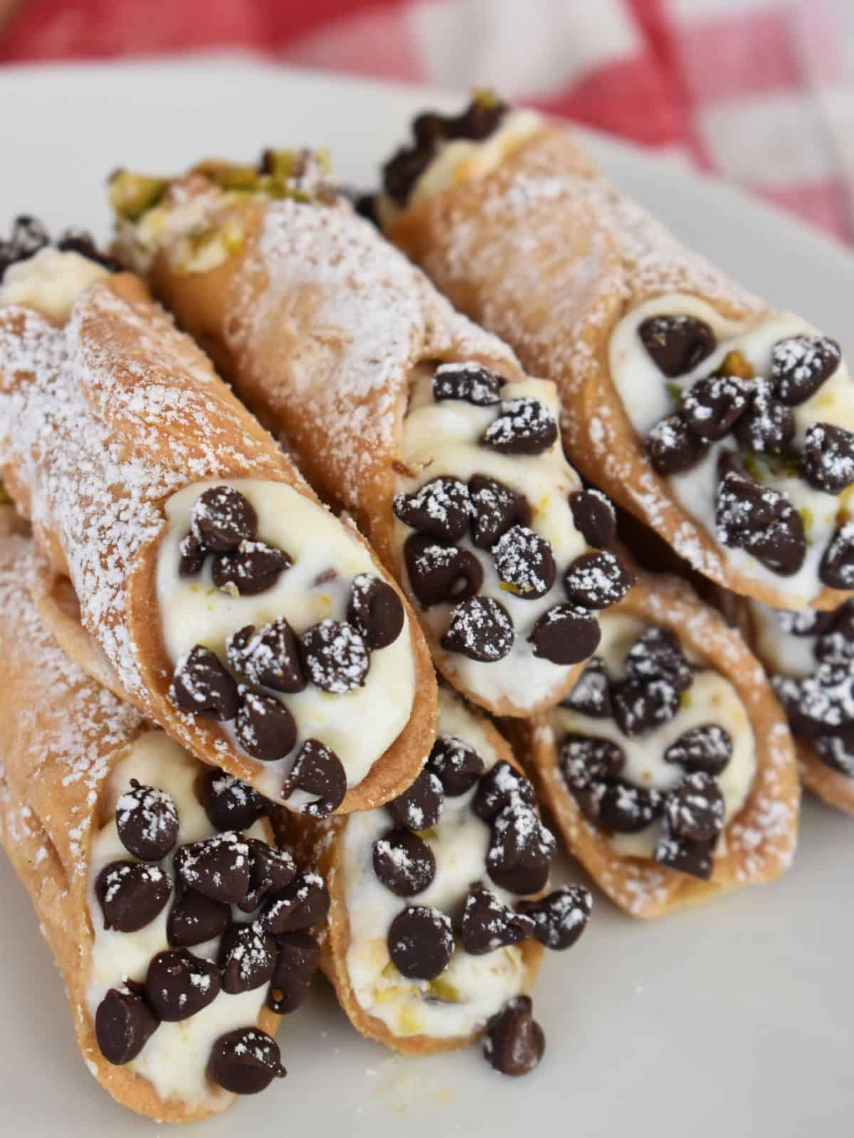 Ricotta Cannolis on a white plate with a checkered napkin in the background. 