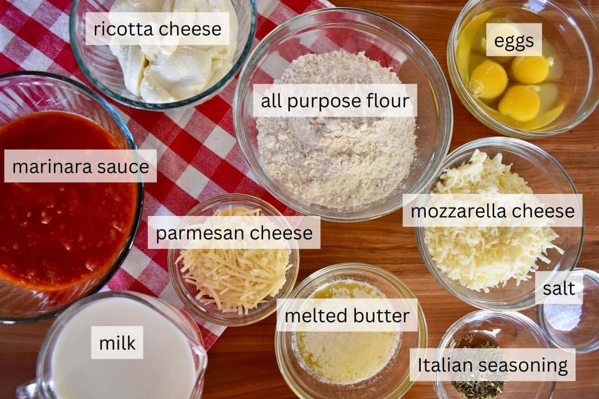 Ingredients for recipe including flour, butter, salt, eggs, ricotta cheese, mozzarella, parmesan, and marinara sauce. 