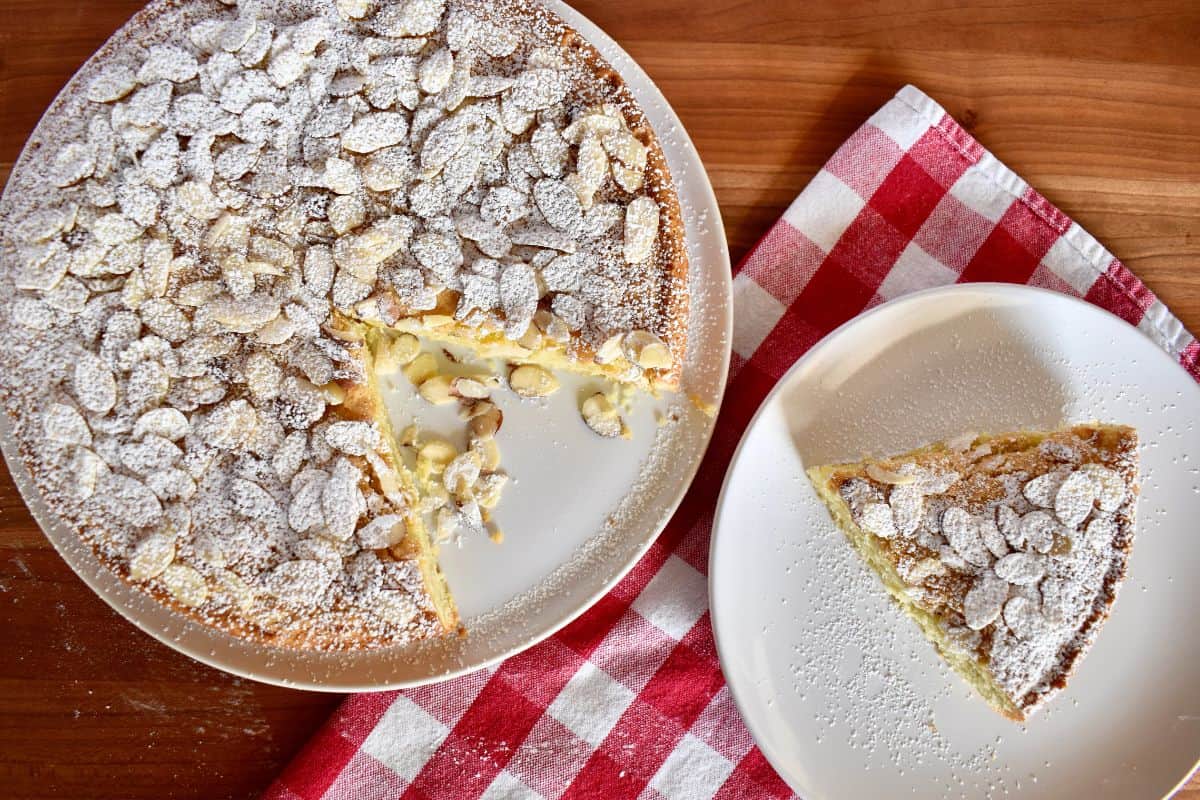 Overhead photo of Italian Almond Cake with sliced almonds and powdered sugar sprinkled on top. 