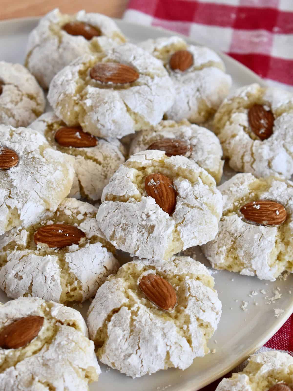 Sicilian Almond Cookies with a whole almond on top on a white plate. 