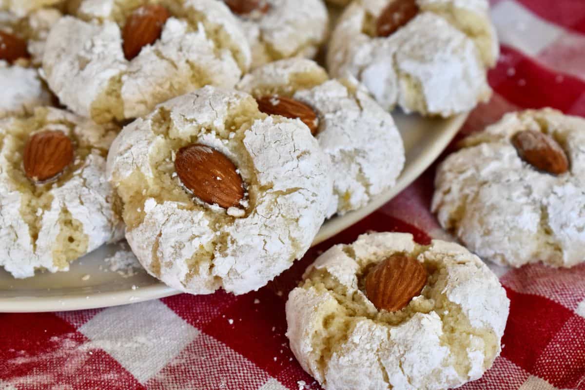 Sicilian Almond cookies on a white plate on a checkered napkin. 