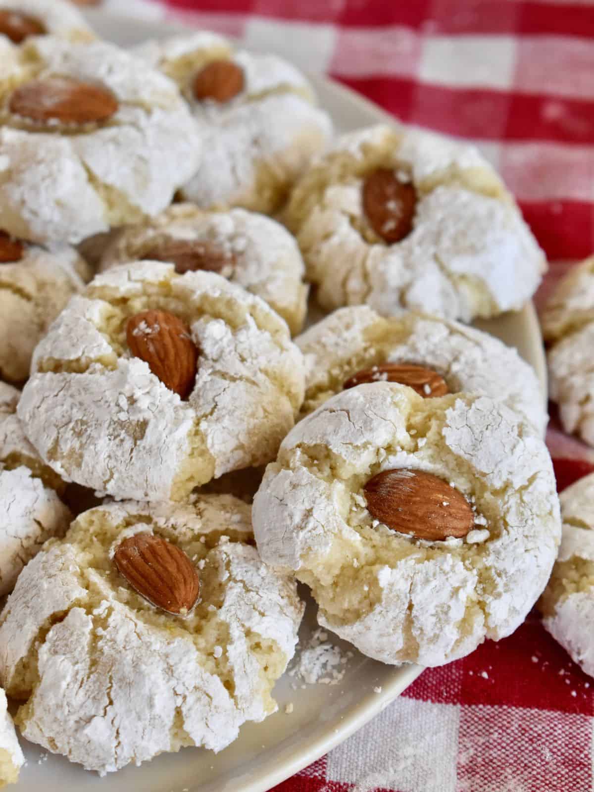 Sicilian Almond Cookies with a whole almond pressed on top on a white plate. 