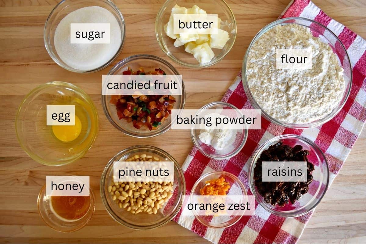 Ingredients for recipe including flour, butter, raisins, pine nuts and candied fruit. 
