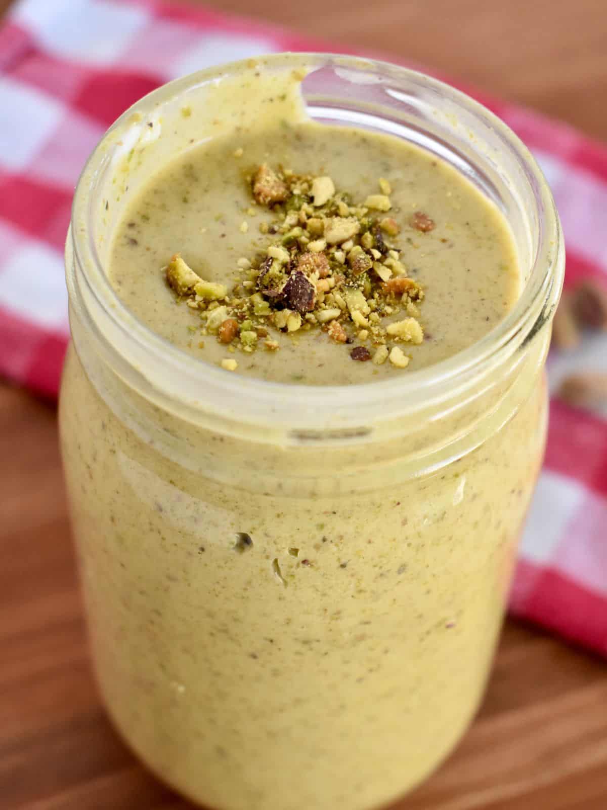 Italian Pistachio Cream in a jar with chopped pistachios sprinkled on top. 
