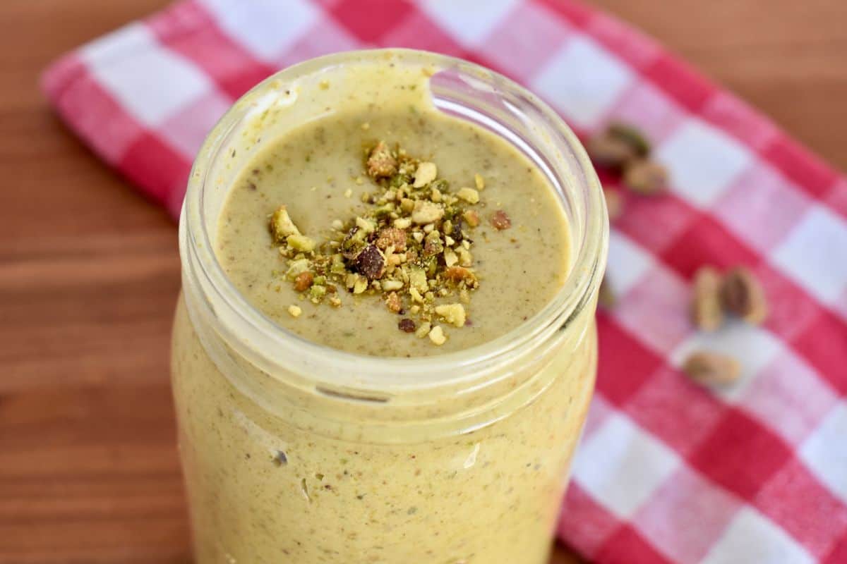 Italian Pistachio cream in a glass mason jar with crushed pistachios sprinkled on top. 