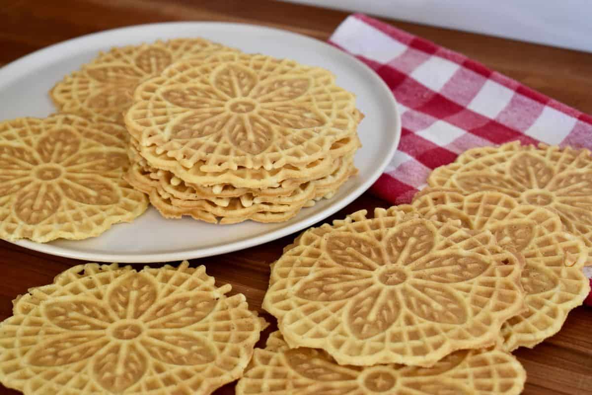 Pizzelle Cookies on a plate without powdered sugar on them. 