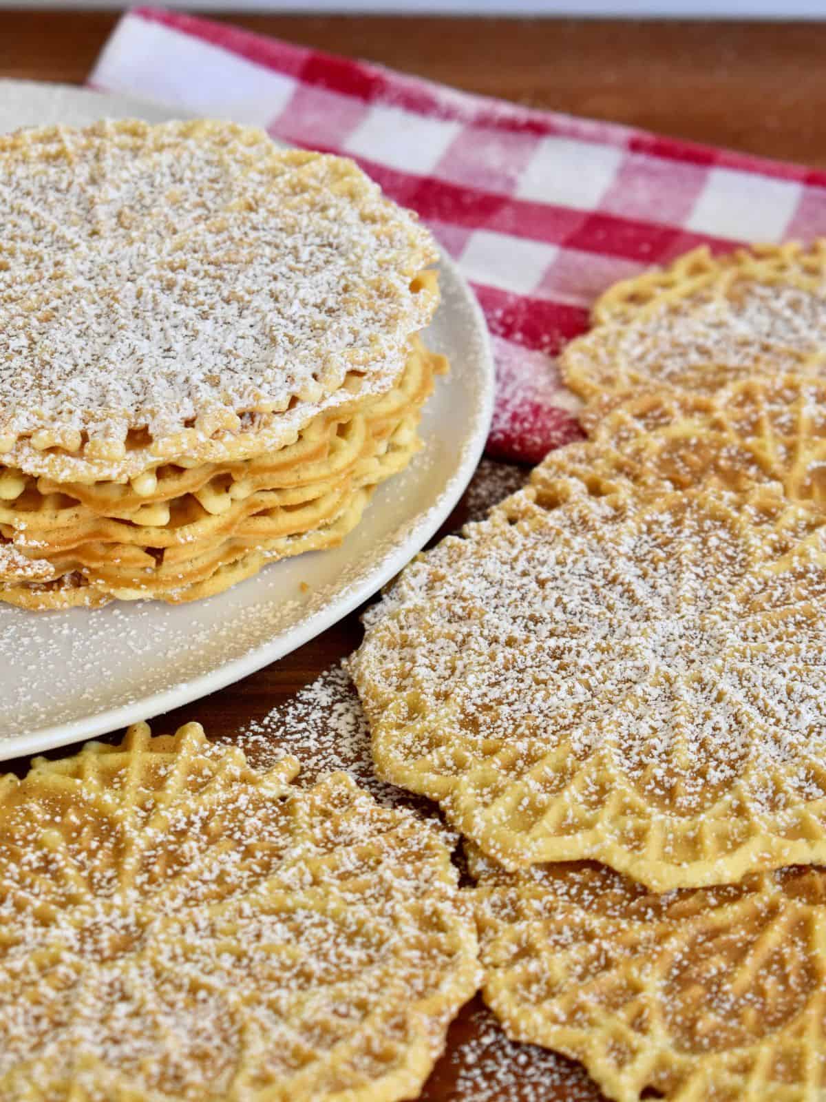 Pizzelle cookies with powdered sugar sprinkled on them. 