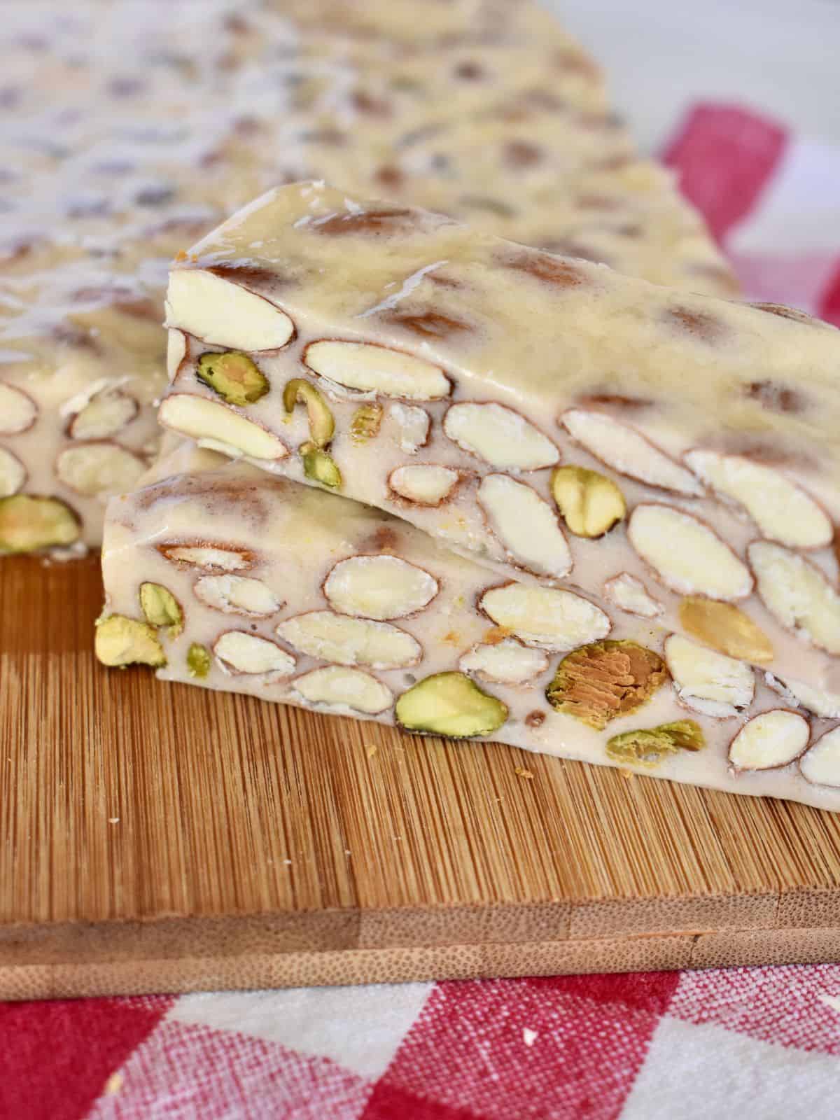 Torrone on cutting board with a checkered napkin underneath. 
