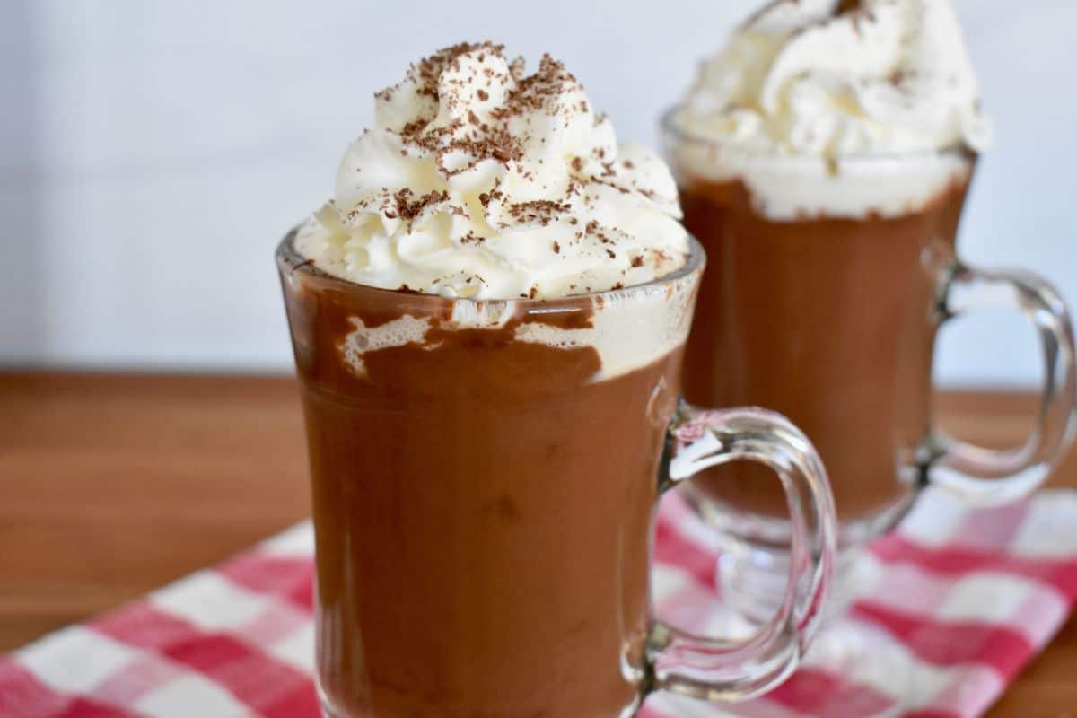 Italian hot chocolate in a glass mug with whipped cream on top. 