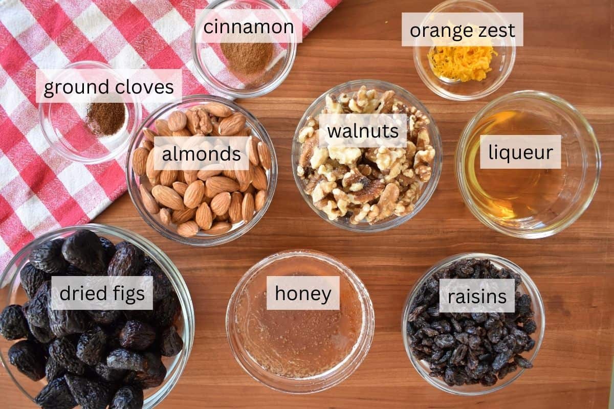 Ingredients for recipe including figs, raisins, almonds, walnuts, honey, orange zest, and cinnamon. 